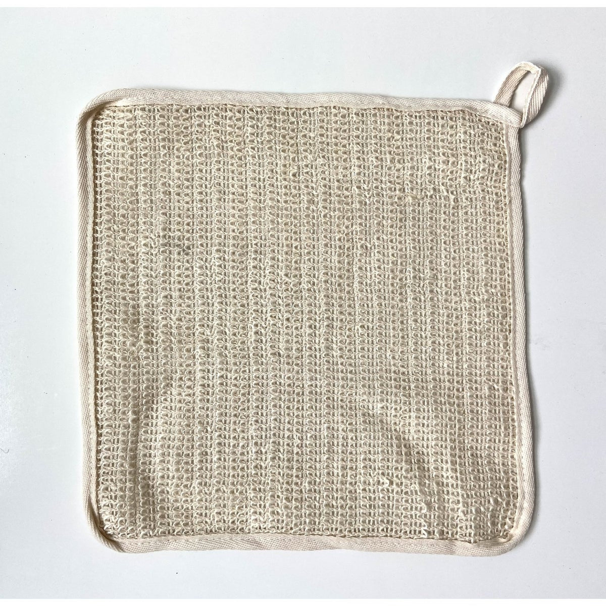 Cream colored washcloth on a white background.
